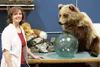 Juli Wolter poses in front of two of the animal mounts she has built in her shop on Bogard Road Saturday morning. Wolter said she loves the artistry of taxidermy. ANDREW WELLNER/Frontiersman
