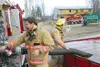 Hugh Matthews, an Engineer with the Central Mat-Su Fire
Department, adjusts the flow from a folding tank set up on the
Palmer/Wasilla highway near Cottonwood Creek, as fire crews
responded Fr