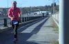 DeeDee Jonrowe, of Willow, runs across the David Douthit Veterans Memorial Bridge in Soldotna during the Kenai River Marathon in 2014. Jonrowe used the time she ran in the race to qualify for