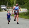 Jordan Manelick, of Palmer, has a guest join her as she runs the final stretch of the Why Not Tri triathlon. Bruce Eggleston/matusports.net