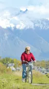 ROBERT DeBERRY/Frontiersman Ellen Sherwood enjoys the break in
the recent rainy weather to take her bicycle for a spin along the
Palmer-Wasilla Highway. For a complete weather forecast, see p