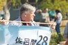 Palmer City Manager Joe Hannan carries a banner for the Sister City program during the 2014 Alaska State Fair Parade in Palmer. Hannan has announced his plans to resign ahead of the end of hi