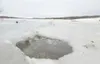 ROBERT DeBERRY/Frontiersman A hole in the ice hints of the
danger in the channel between the upper and lower Wasilla Lake.
Although most of the lake is frozen the channel between the two
sect