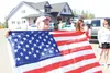 As the American Legion float carrying several local military service members passed by during the Fourth of July Parade in Wasilla Friday, Gwendolynne Teutsch sprang forward and unfurled this