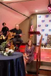 Magy Helle, a two-time cancer survivor from the Mat-Su, enjoys the entertainment provided by husband and caregiver N. Scott Helle at the 2024 Mat-Su Taste of Hope fundraiser for the American 