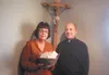 Mary Pfiffner and Father Scott Garett with a basket of cookies Pfiffner made. She used a $20 gift to make cookies to sell to benefit a local food bank. Courtesy photo
