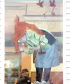 ROBERT DeBERRY/Frontiersman Window artist Tatyana Varnikova
works on a Christmas reindeer in the window of the Valley Hotel and
Café in Palmer in final preparation for Colony Christmas, which