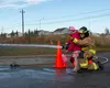 U.S. Air Force Airman 1st Class Nicholas Martin, a 673d Civil Engineer Squadron Fire and Emergency Services firefighter, teaches the child of U.S. Army Capt. Christopher Phinney, a 103rd Civi