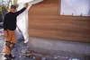 Bly Windstorm, of Port Townsend, Washington-based Earth Dwell, LTD, pulls back a tarp to reveal lines of packed earth curing in the walls of Alaska's first-ever packed-earth house Thursday in