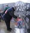GREG JOHNSON/Frontiersman Mat-Su Valley resident June Burkhart
places a wreath at the Veterans Wall of Honor in Wasilla on Sunday
in honor of Veterans Day. She placed the wreath for her husba