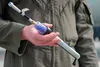 U.S. Air Force Tech. Sgt. Thomas Boyd, the 3rd Wing noncommissioned officer in charge of Agile Combat Employment, poses for a photo holding his solution to the radio deficiency in the E-3 Sen