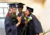 American Charter Academy graduates Helen Allison, Nyajuok Rauch and Kristy Obruk look at a group photograph they snapped before the start of Monday’s 2012 graduation ceremony at Wasilla Bible