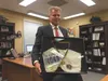 Mat-Su Schools Superintendent Gene Stone in his office with a display from the 1996 Boston Marathon, where he finished in a time of 3:05. That was his last marathon until this October, when h