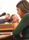 Palmer Police Dispatch Communications Supervisor Whitney Daw, holding her 1-month-old daughter Louise Clark, shares her view of City Manager Stephen Jellie with the city council. J. David McC