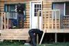 Anchorage police officers check the outside of the house of Discreet Deliveries owner Rocky Burns Thursday evening. APD officers, assisted in some cases by Alaska State Troopers, visited at l