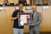 Ryan Redington holds up a proclamation recognizing his historic achievement and poses for a photo with Mat-Su Borough assembly member Dmitri Fonov. Jacob Mann/Frontiersman