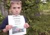 Wyatt Reinhart holds a poster for Abby, his 18-month-old English bulldog trained as a service dog. The dog disappeared from the family’s yard off Twilight Drive the afternoon of May 23. ROBER
