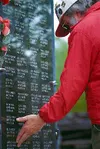 One of many who attended Monday's Memorial Day service, this man
paused, eyes closed, as he slowly ran his hands across a name
engraved on the granite wall at the Veterans' Wall of Honor
Mond