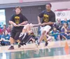 Tanner Barclay and Zachary Tucheck bring Joshua Hughes around the oval during the wrist carry event at the Native Youth Olympics state competitiion in Anchorage. Hughes won the event and brok