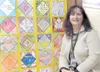 GREG JOHNSON/Frontiersman Sharon Powder has been the school
nurse at Iditarod Elementary School for 17 years. Here she poses
with a large quilt a classroom made for her as a thank you for her