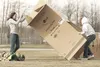 Wasilla's Kelseay Lund, left, and Lindsey Boll fight a strong wind while getting their cardboard house together for the Family Promise Mat-Su Cardboard City event in this 2008 Frontiersman fi