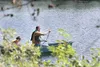 A canoe with a couple of fishermen paddle across the water of
Loberg Lake Thursday afternoon in hopes of finding the hot fishing
spot on the lake. Loberg Lake is stocked by the Alaska Departm