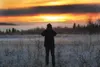 ROBERT DeBERRY/Frontiersman The sun sets as an amateur
photographer takes a photo from the Palmer Hay Flats off the Glenn
Highway in this 2008 file photo.