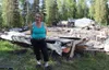 Audrey Williford stands in front of the wreckage of her two-story house, which burned to the ground May 19 outside of a fire service area. Williford and husband Michael were left homeless by 