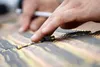 A soldier lines up linked belts of 5.56mm ammunition on a range as paratroopers assigned to the 1st Battalion, 501st Parachute Infantry Regiment, 4th Infantry Brigade Combat Team (Airborne), 