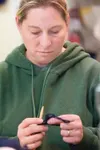Gail Schuler works her stitch during knitting class Saturday
afternoon. (ROBERT DeBERRY/Frontiersman)