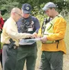 (ROBERT DeBERRY/Frontiersman) Palmer Police detective Kelly
Turney looks at a map of the area with members of the Alaska
Mountain Rescue Group and Mat-Su Search and Rescue Wednesday
afternoon