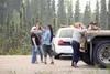 Area residents stand behind a semi-truck and trailer positioned as a road block  at Mile 70, Parks Highway Sunday evening. The evacuation area was pushed back to Nancy Lake Parkway a few hour