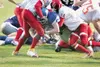 ROBERT DeBERRY/Frontiersman Palmer Moose Coleman Ahrens drives
over the goal line with two West Valley Wolfpack defensemen in tow
to take the win for the Palmer Moose.