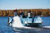 Paddles on either side of the City of Wasilla public works' departments newly acquired aquatic weed harvester kick up spray along the shoreline of Lake Lucille near Carter Park Tuesday. The b