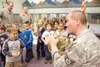 U.S. Air Force Staff Sgt. Craig Matta, above, plays the French
horn Monday morning for Kail Davey, 5, left, and a group of Swanson
Elementary students who have family members in the military.