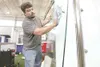 ROBERT DeBERRY/Frontiersman Replacement Glass Company's Terry
Rehms cleans a piece of glass for his booth at the Fall Home Show
Thursday afternoon.