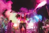 Jamie Liebert, owner and director of the Color Fun Fest 5k, spreads his arms wide to cover as many people in colorful fog as possible at a previous Fun Fest. The event will be held in Alaska 