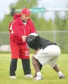 ROBERT DeBERRY/Frontiersman Assistant coach Mark Humm works with
a Wasilla footbal player on proper body position during a Monday
practice at Wasilla High School.