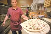 Pizza chef Cecilio Calugay prepares to put a ‘Mama Mia’ pizza in the oven at the new Tuscana Restaurant in the Fishhook Plaza on Wasilla-Fishhook Road. The restaurant features pizza, calzones