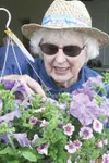 Valley Garden Club member Dawn Caswell primps a colorful hanging
basket at Saturday’s annual sale benefiting the club. GREG
JOHNSON/Frontiersman