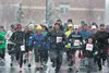 More than 150 runners leave the starting line in snowy conditions Saturday at the 2013 Mat-Su Rotary 5-K at Colony High School. ROBERT DeBERRY/Frontiersman.com