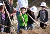 Second grader Aiden Tudor in green, joins other students at the school getting ready fling some dirt during the groundbreaking for the Fronteras Spanish Immersion Charter School Monday mornin