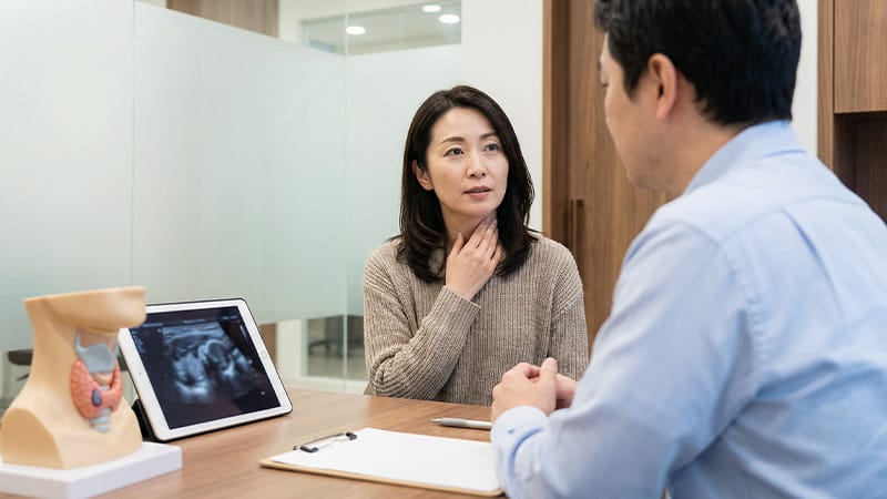 A thyroid patient consulting with a medical professional with a comfortable expression.