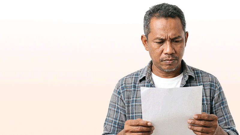 An international patient carefully reviewing a detailed dental implant cost quotation and treatment plan at a clinic.