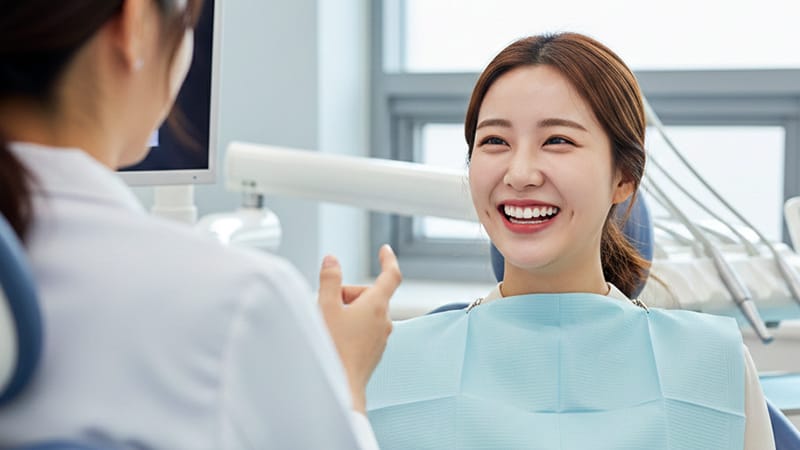 A woman smiling bright and comfortably after completing her dental checkup