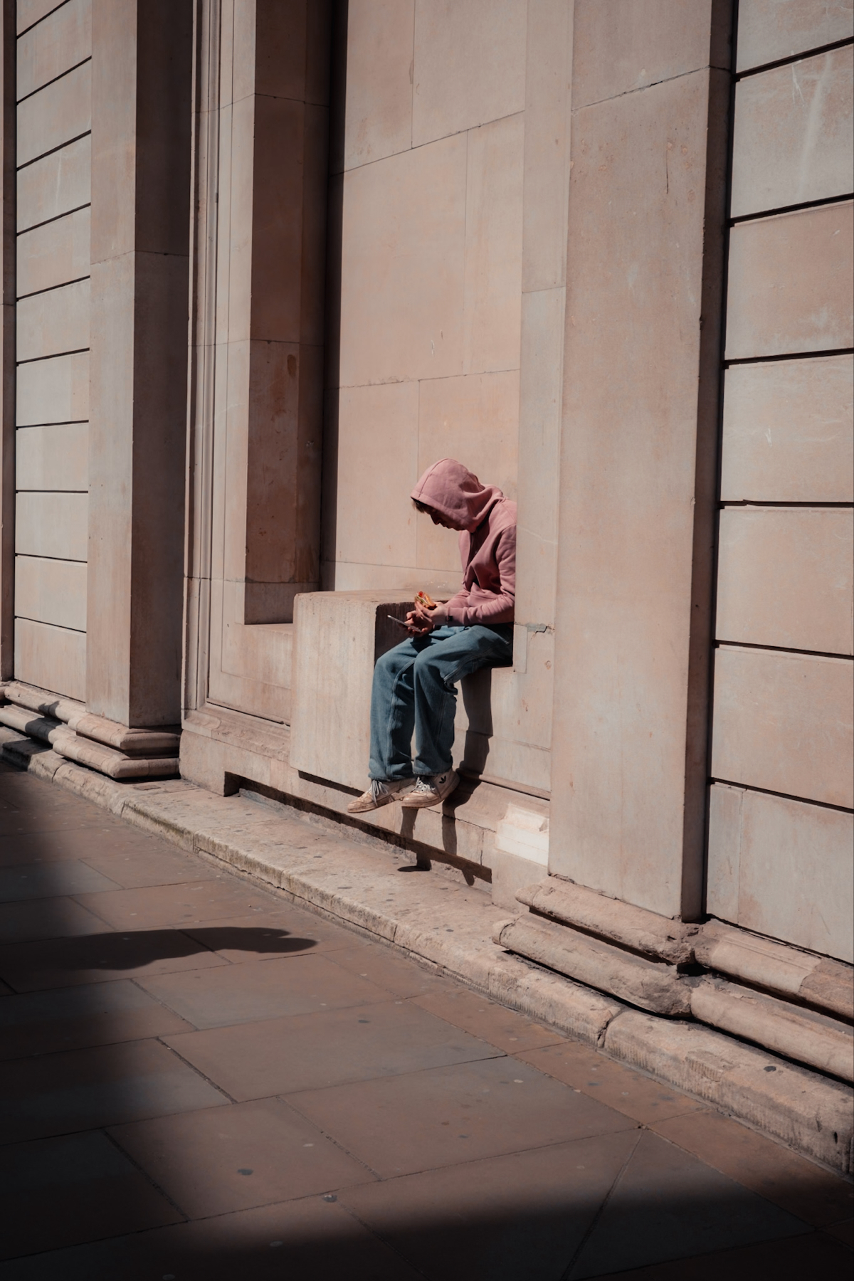 a man sat in the sun surrounded by shadow