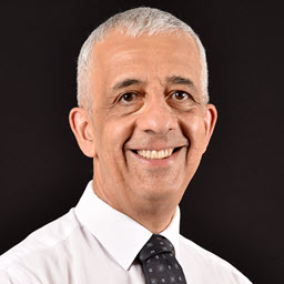 Head shot of Feridun Kadir wearing a white shirt and tie