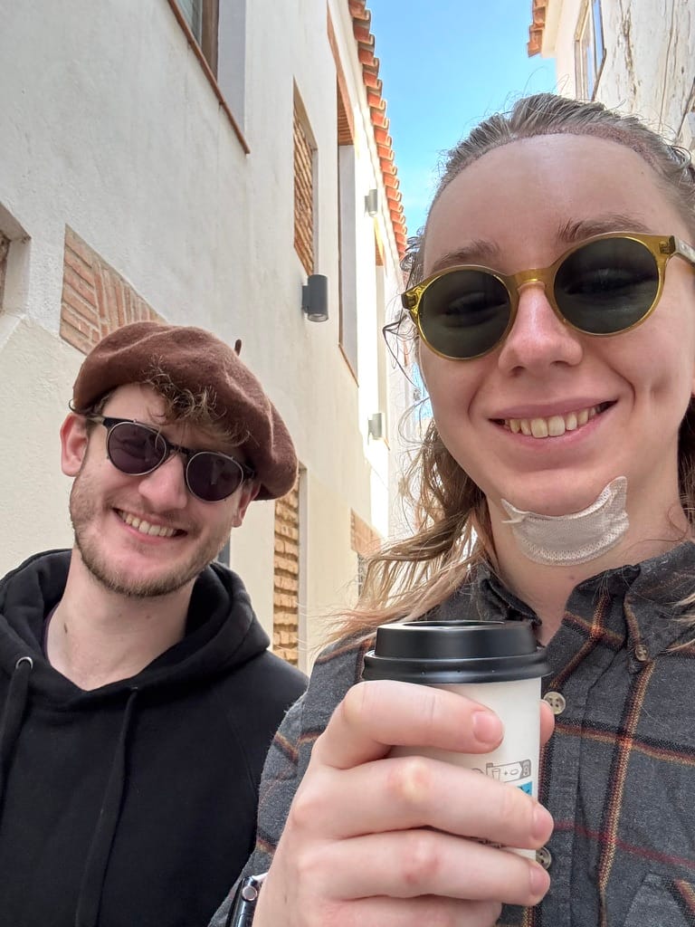 Maisie and her partner, Jon, grinning while walking down a street in the Old Town. Con Cafe. :)