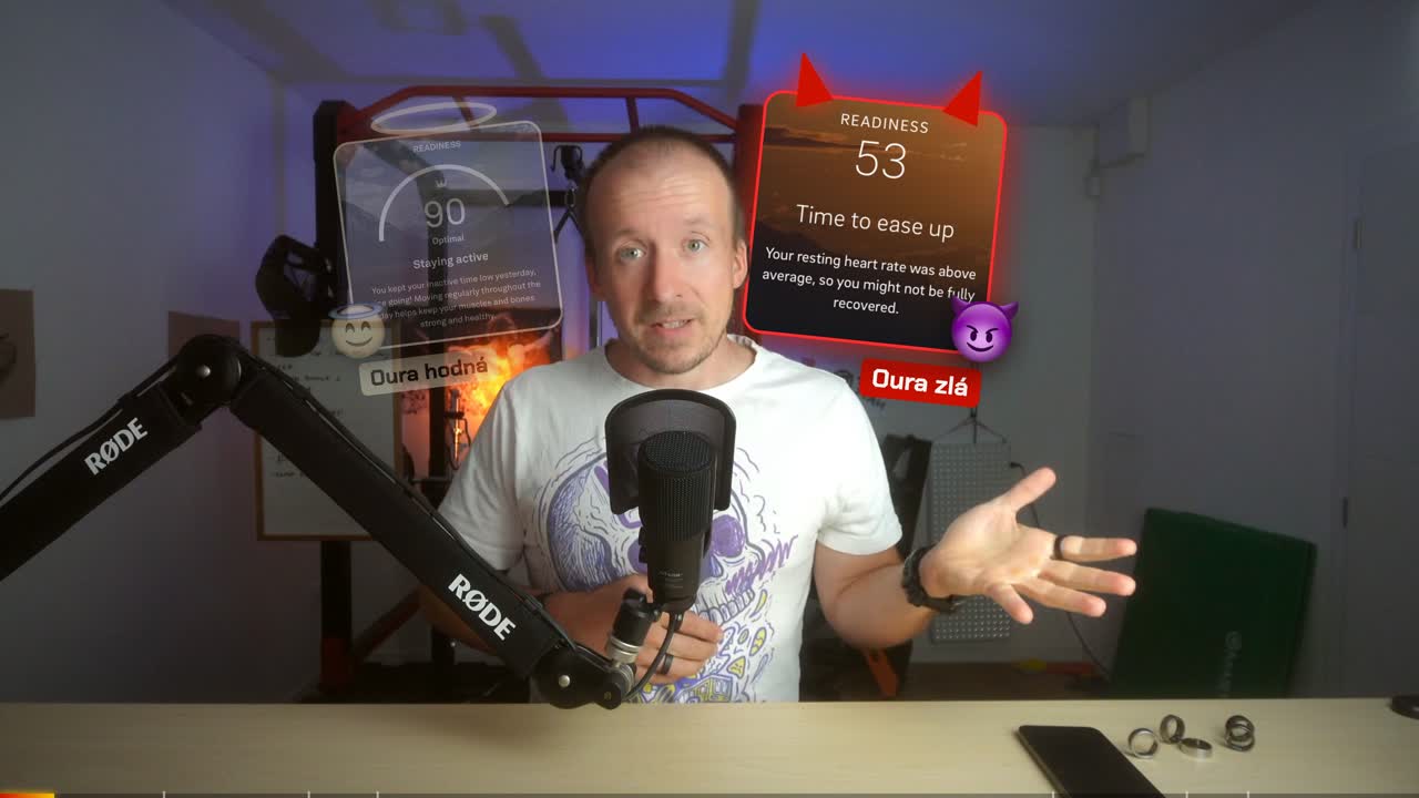 Karty „Oura hodná / Oura zlá“ vykukují zpoza hlavy – postava je vyřezaná přes Apple Vision.