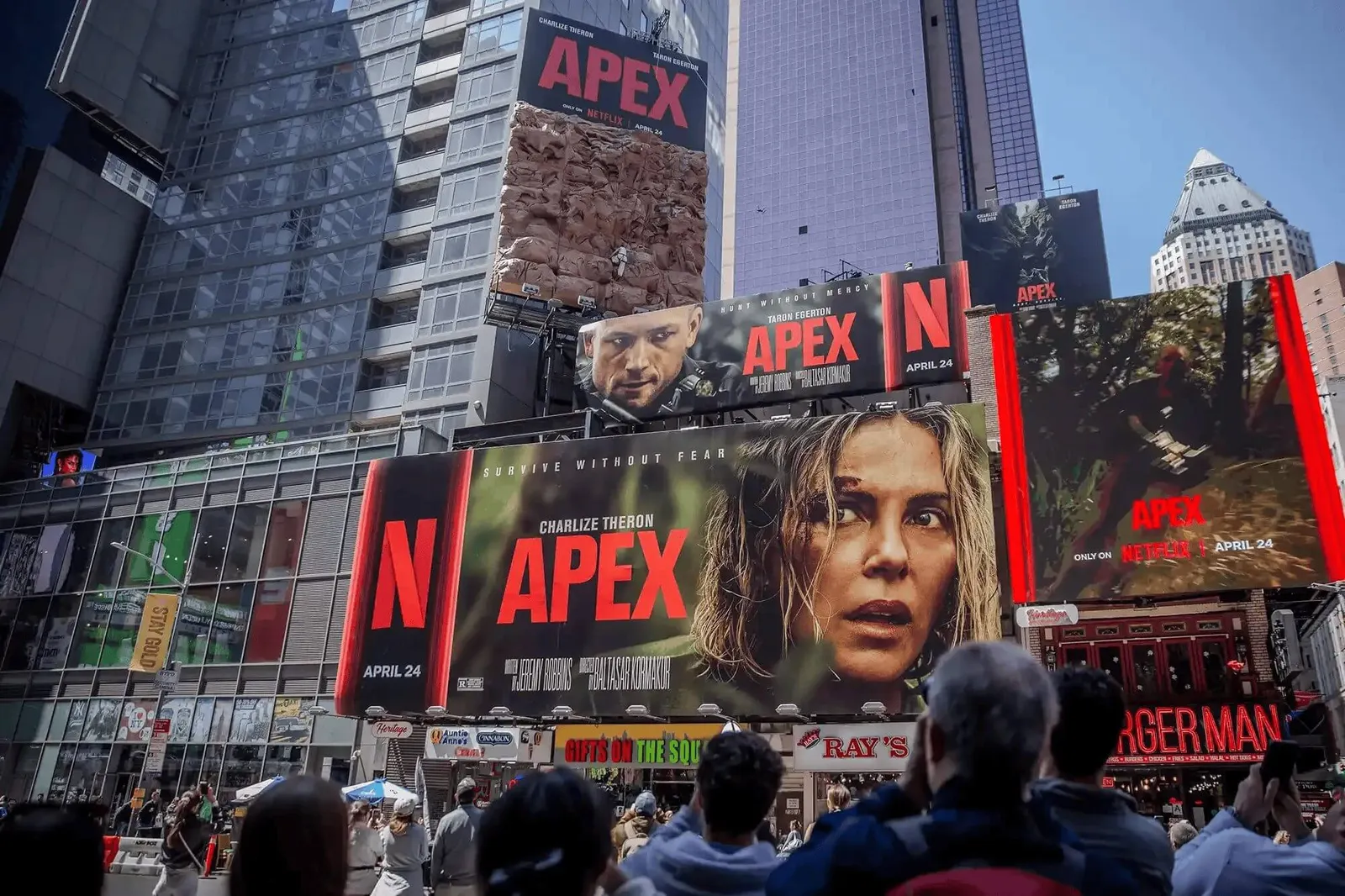 Netflix faz Charlize Theron escalar outdoor gigante na Times Square pra promover filme ‘Apex’